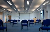 A conference room with a projector and whiteboard